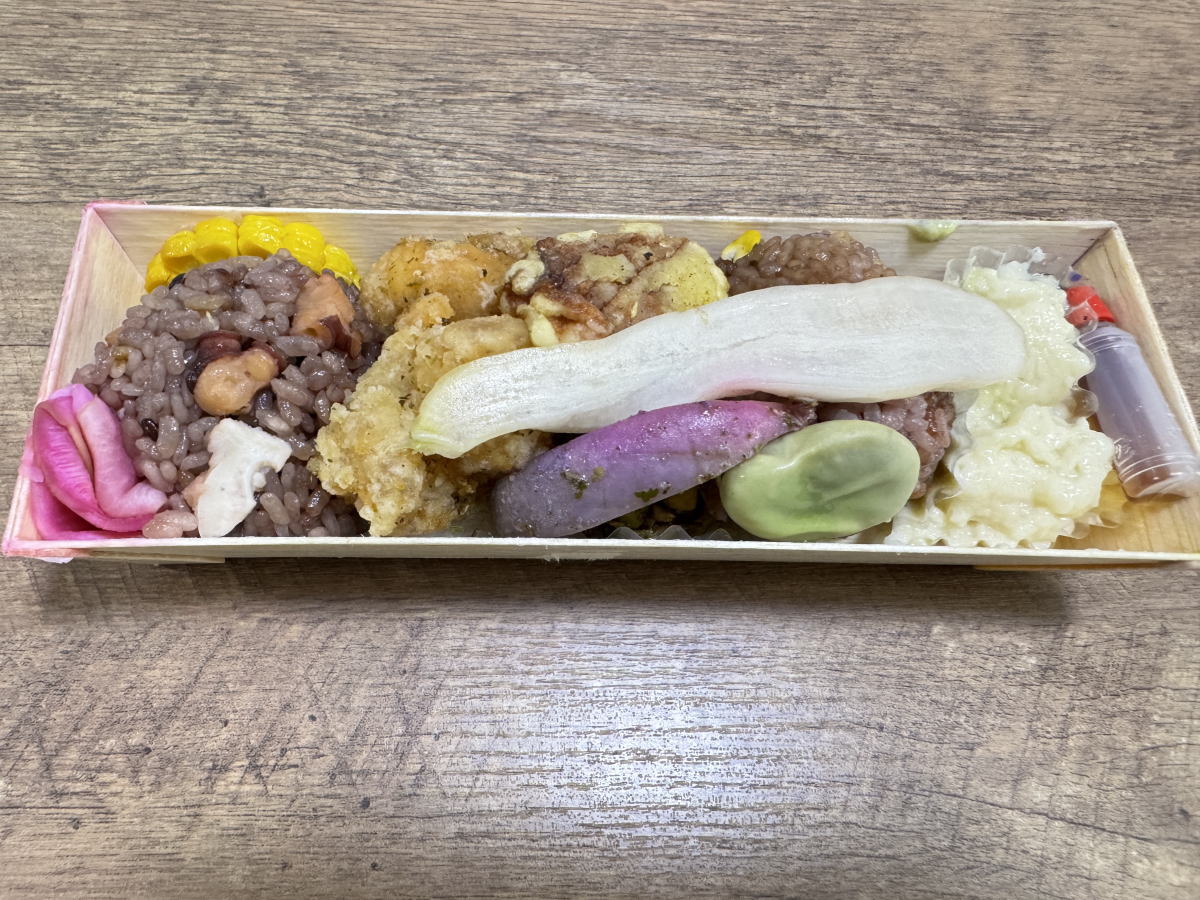 月ノ輪のお弁当の中身。タコ飯・からあげ・長芋などが彩りよく入っている